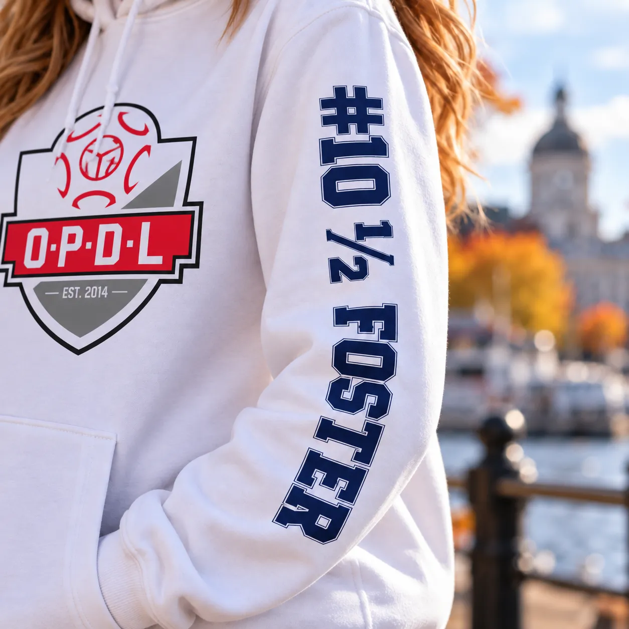 Close-up of the #10½ FOSTER sleeve on a white Kingston United OPDL hoodie
